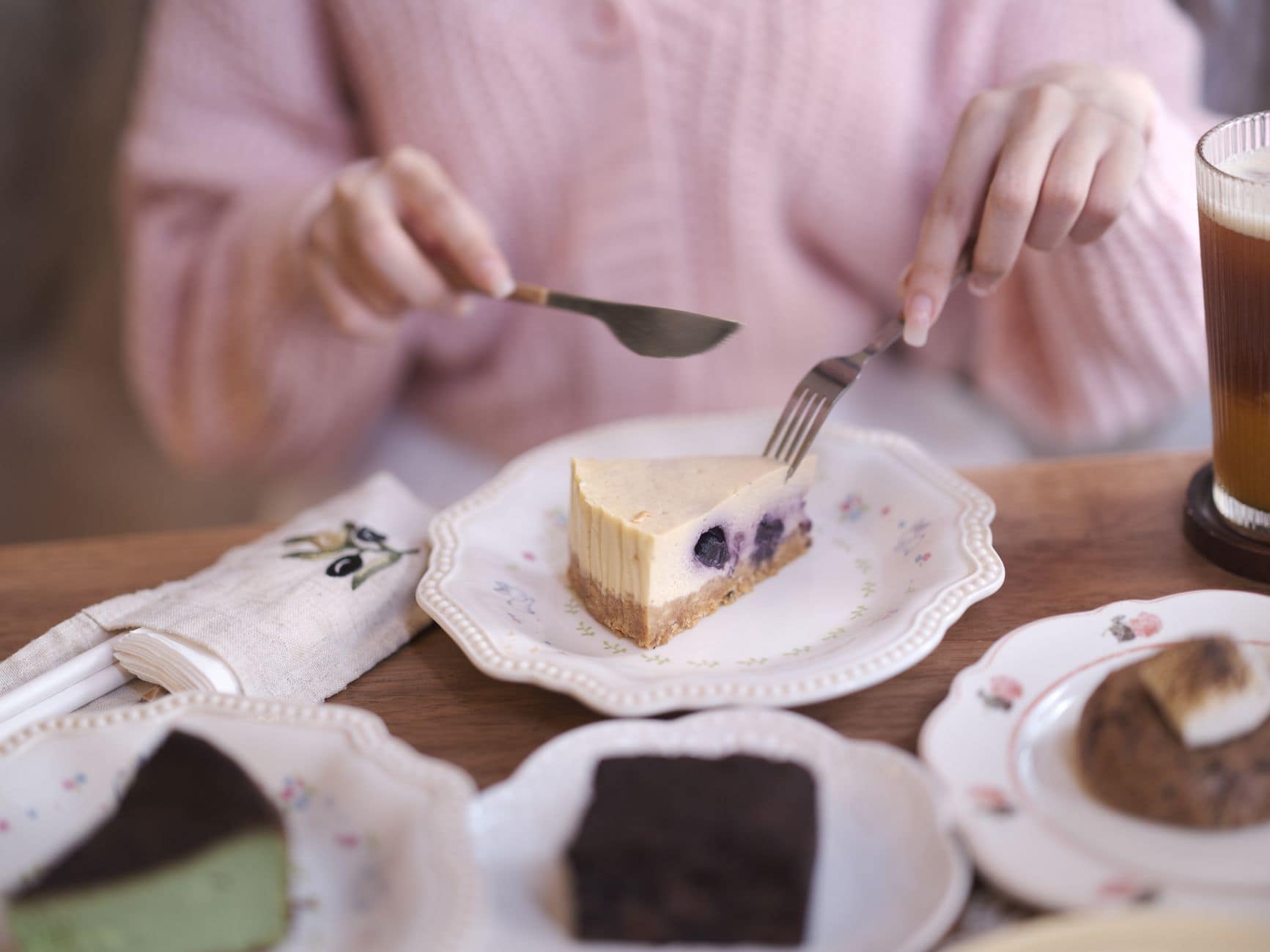 A cozy indoor dessert setting featuring cheesecake and various sweet treats on elegant plates.