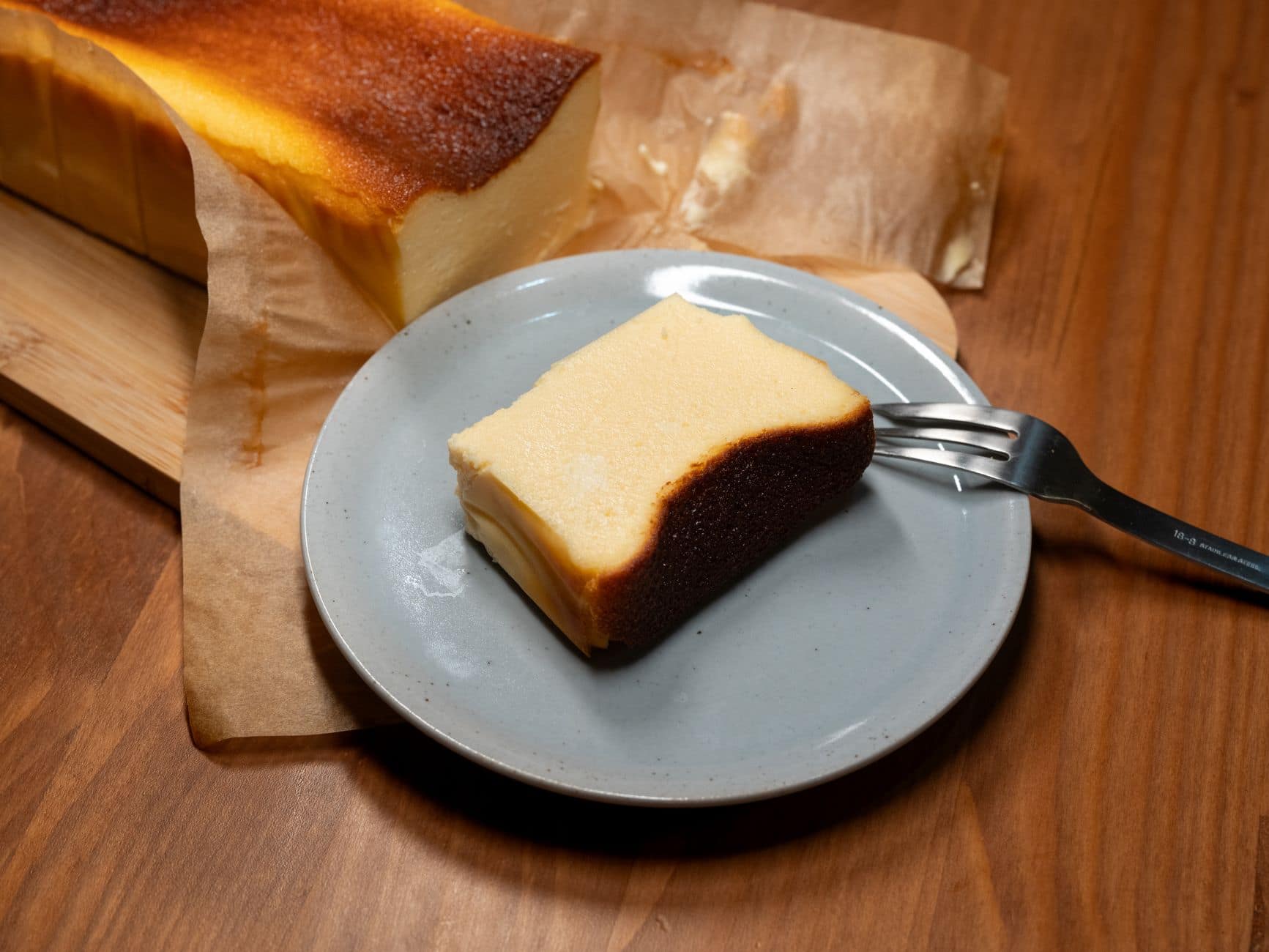 Close-up of a slice of baked cheesecake on a plate, perfect for dessert or snack.