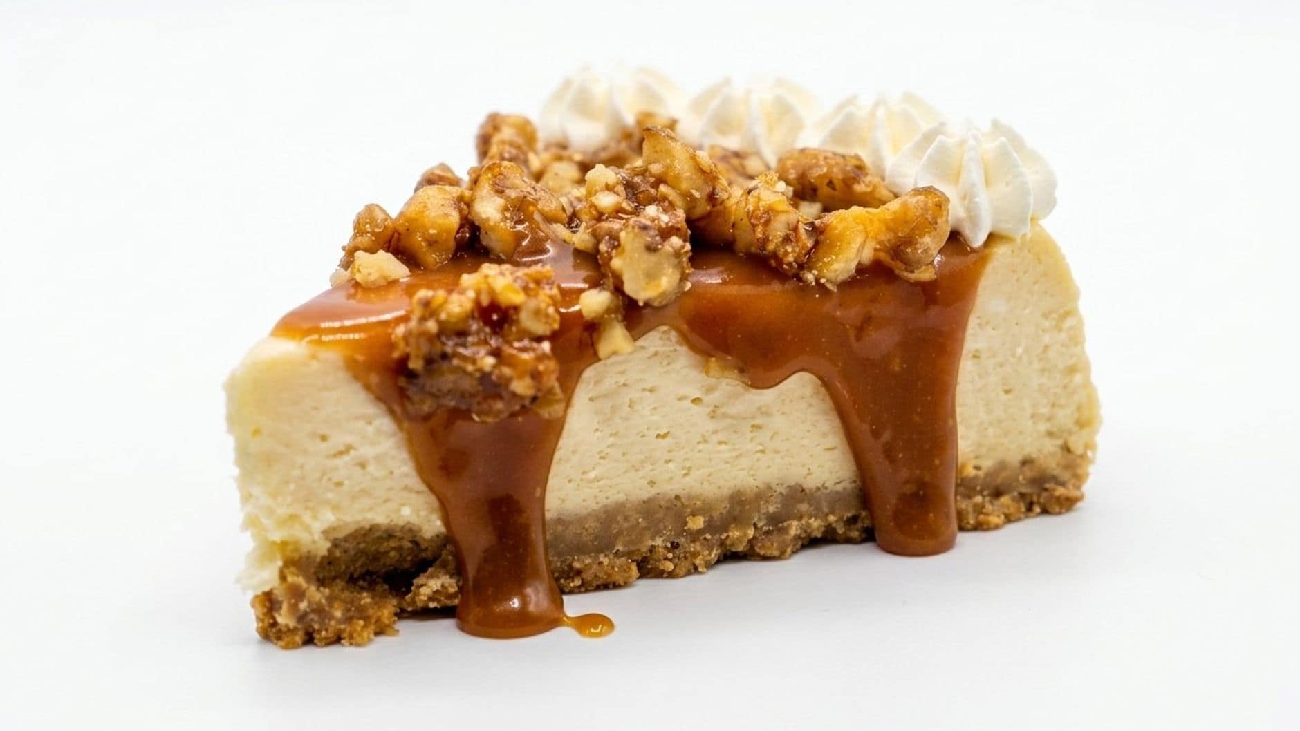 Mouthwatering slice of caramel walnut cheesecake with whipped cream topping.